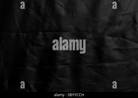Crumpled wavy black fabric with wrinkled texture. Abstract dark background Stock Photo