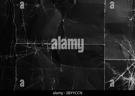 Geometric lines of aged folds and worn wrinkles on a black distressed cardboard surface. Grunge paper dark background Stock Photo
