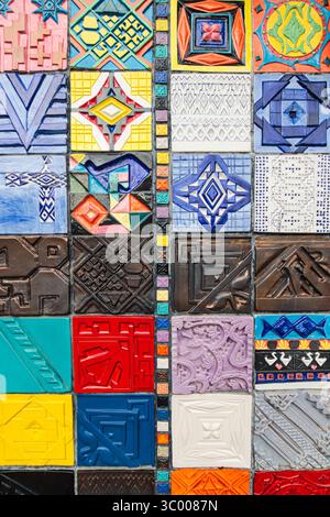 Vibrant abstract pattern of handmade ceramic wall tiles, close-up with detailed texture and artistic appeal. Stock Photo
