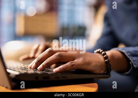 Independent woman using laptop for remote job tasks at home office, doing research and enjoying the benefits of schedule flexibility. Embracing the modern lifestyle of freelance work. Close up. Stock Photo