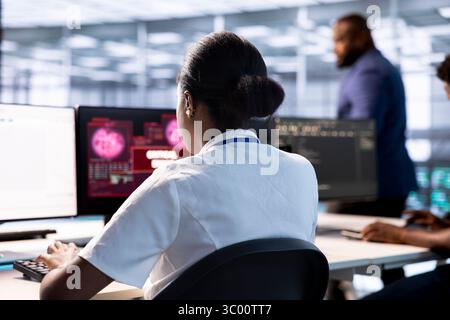 Server farm IT professional trying to protect hardware from hacker attack stealing info. Woman in data center trying to get rid of virus after seeing security breach alert on display Stock Photo