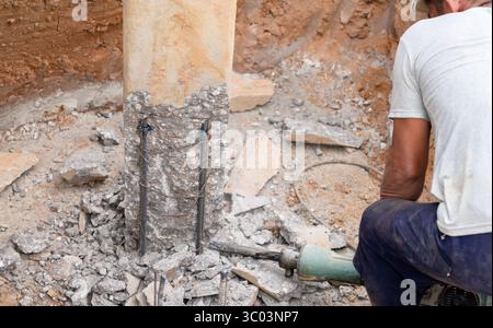 The workers are using a jackhammer to break the concrete pile heads. Stock Photo