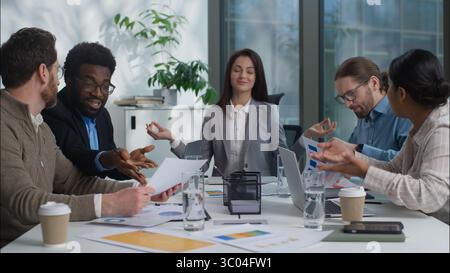 Calm businesswoman Caucasian woman ceo boss manager leader relaxing meditate lotus position in background team quarrel conflict shouting arguing Stock Photo