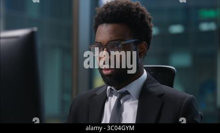 Close up focused concentrated African American man businessman business male ethnic guy office worker manager employee typing computer keyboard pc Stock Photo