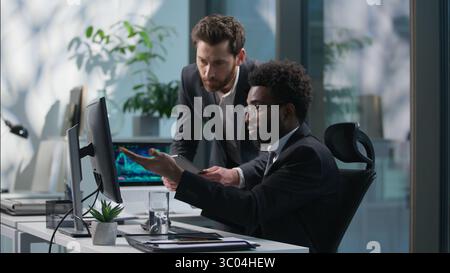 Two people businessmen talking African American employee Caucasian boss leader business working together teamwork discussing project males coworkers Stock Photo