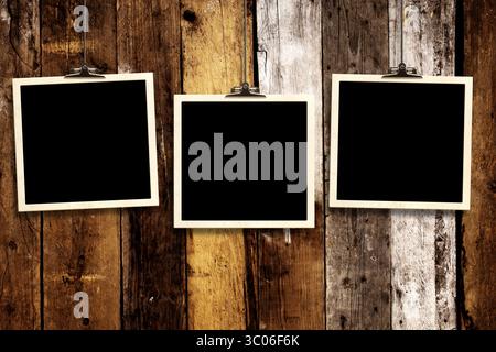 Photos hanging on paper clips against wall. Nostalgic Picture album with old photoframe. Template with three retro frame photos. Moodboard pictures al Stock Photo