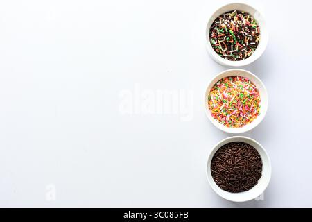 Three Bowl of Various Hagelslag, Donut Candy Rainbow Sprinkles Topping. Chocolate and Rainbow Color Meises on White Background, Copy Space Stock Photo