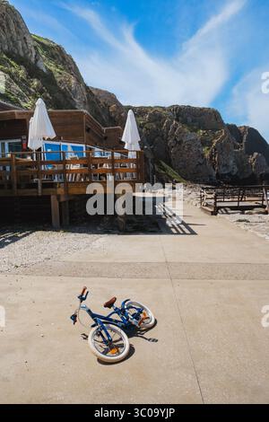 Sunny Day Scene with a Bicycle and Outdoor Dining Area on the Coast Stock Photo