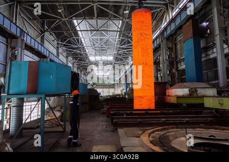 Hardening of pipe in special furnace, hot iron pipe on crane. Stock Photo
