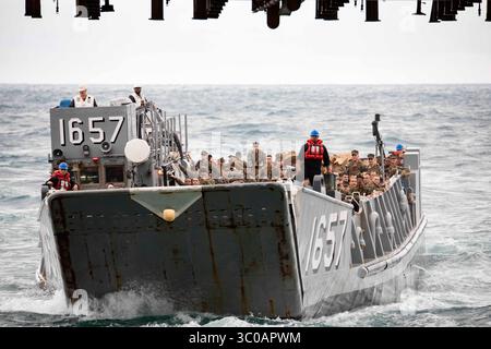 A landing craft utility enters the well deck of the amphibious assault ...
