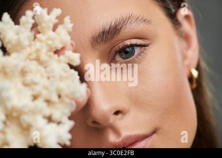 A young woman showcases her natural beauty with perfect skin in a summer studio setting. Stock Photo