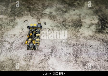 Small circuit board with various components on a textured backdrop for an abstract effect Stock Photo