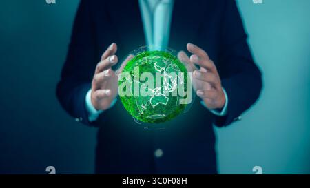 Sustainable business embracing eco-friendly technology with a businessman holding a glowing green earth to represent global environmental responsibili Stock Photo