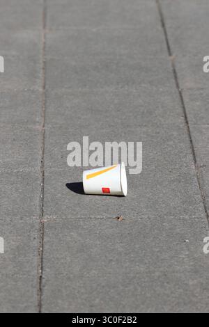 White paper drinks cup discarded on pavement in radcliffe greater manchester uk Stock Photo