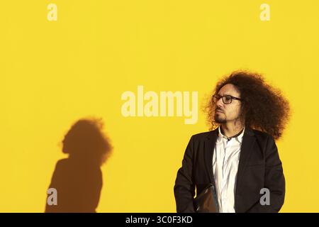 Young man in eyeglasses in formal suit on isolated background. Business man on isolated background looking to the side Stock Photo