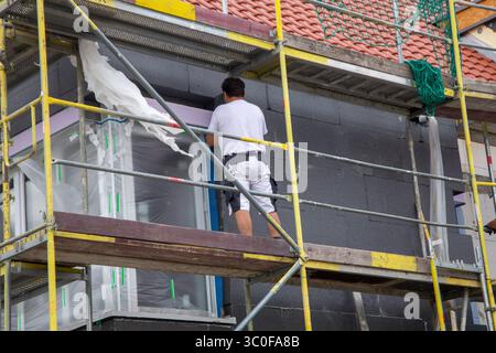 Construction workers insulates house facade Stock Photo