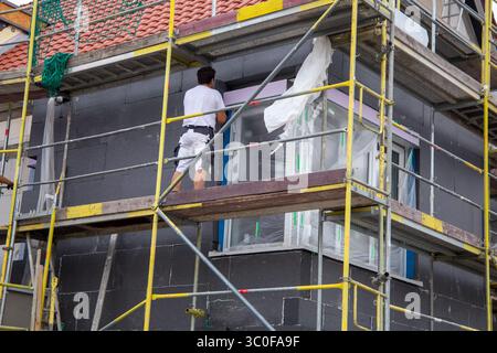 Construction workers insulates house facade Stock Photo