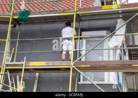 Construction workers insulates house facade Stock Photo