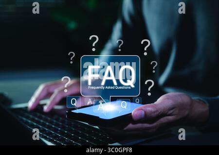 FAQ Frequently Asked Questions Digital Concept. Man holding smartphone with glowing FAQ icon above screen, symbolizing digital frequently asked Stock Photo