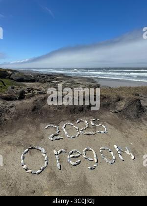 The words "2025 Oregon" written in shells in the sand on the Oregon coast in Yachats on a summer day. Stock Photo
