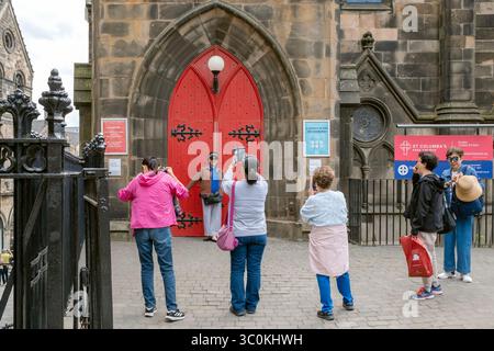 Tourists pose for photographs outside St Columba's Free Church, Johnston Terrace, Edinburgh, Scotland, UK. Stock Photo