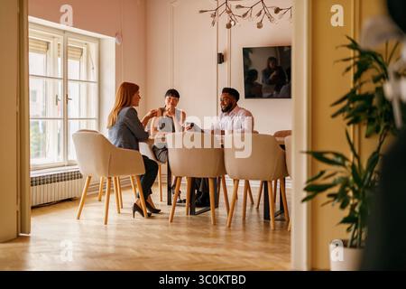 Colleagues discussing project ideas and strategies at office desk while collaborating in business meeting Stock Photo