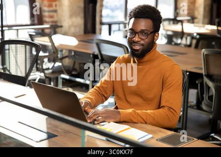 African american young man with laptop working in the office Stock Photo