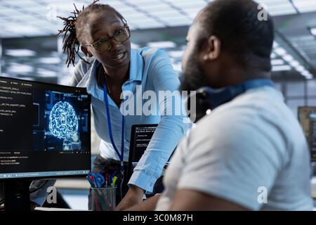 Manager admonishing AI programmer after making error damaging high tech data center. Supervisor scolding artificial intelligence expert after doing mistake in server room Stock Photo