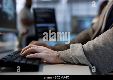 Close up of engineer implementing cybersecurity measures to protect data center assets and information. Man typing on keyboard in server hub, monitoring metrics to enhance operational effectiveness Stock Photo
