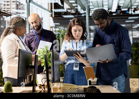 Ambitious work team collaborates on a financial planning project in an office, emphasizing teamwork and data analysis to make informed decisions for future organizational development. Stock Photo