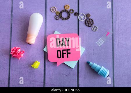 Paper notes with text DAY OFF on blue background. Stock Photo