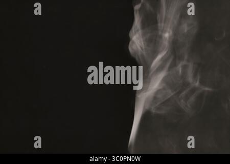 Abstract figure created by white smoke on an isolated black background to stimulate the subconscious with truly beautiful shapes Stock Photo