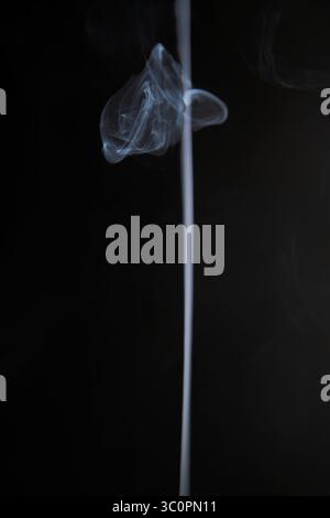 Abstract figure created by white smoke on an isolated black background to stimulate the subconscious with truly beautiful shapes Stock Photo