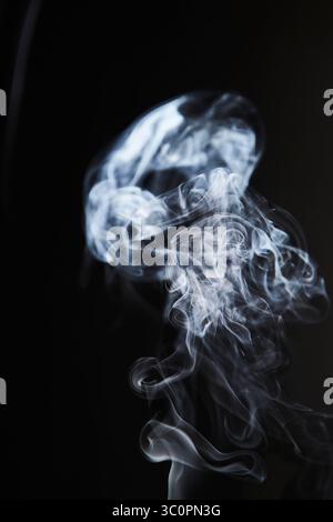 Abstract figure created by white smoke on an isolated black background to stimulate the subconscious with truly beautiful shapes Stock Photo