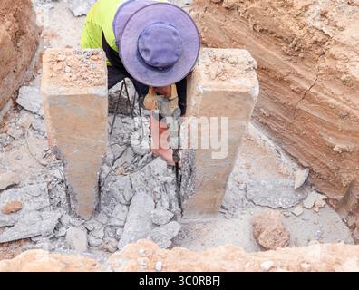 The workers are using jackhammers to break the pile in preparation for cutting the shaft. Stock Photo