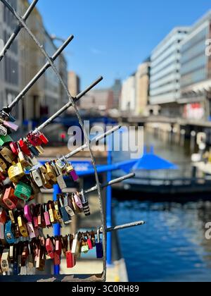 Love locks on a bridge railing over a canal in Hamburg, Germany, symbolizing romantic commitment. Stock Photo