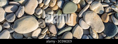 Smooth Beach Stones, a Backdrop of Earthy Serenity, Ideal for Wellness Designs and More Stock Photo