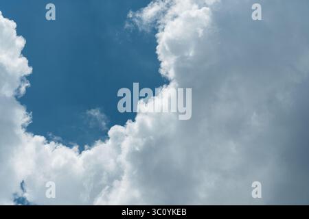 Background of a deep blue summer sky and fluffy white clouds Stock Photo
