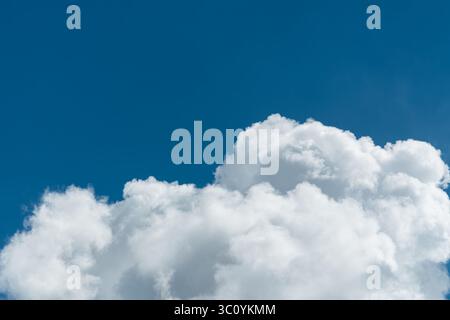 Background of a deep blue summer sky and fluffy white clouds Stock Photo