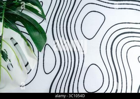 Minimalist white textile with organic black line patterns and monstera leaf decor. Ideal for use in graphic design, layout backgrounds, or calming. Stock Photo