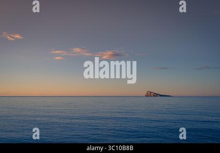 Spain - Just after sunrise and the cliffs on Benidorm Island reflect the early morning sunlight Stock Photo