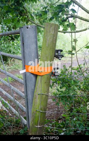 an old gate no longer being used tied up with orange tape Stock Photo