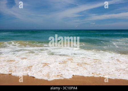 Foamy waves of sea sandy beach, surf on empty coast Stock Photo