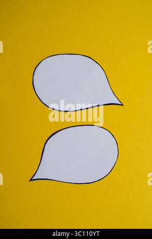 Two Blank Speech Bubbles on Yellow Background Stock Photo