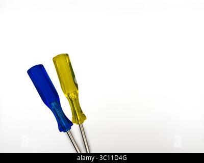 Two small colored plastic screwdrivers on a white background, blue and yellow. copy space, flay lay, top view. High quality photo. Stock Photo