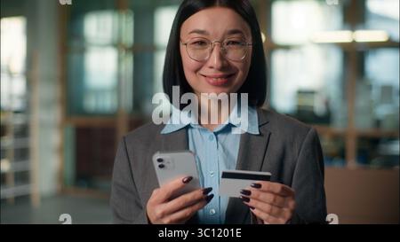Asian businesswoman business woman girl using mobile phone in office building Chinese Korean Japanese female entrepreneur browsing smartphone shopping Stock Photo