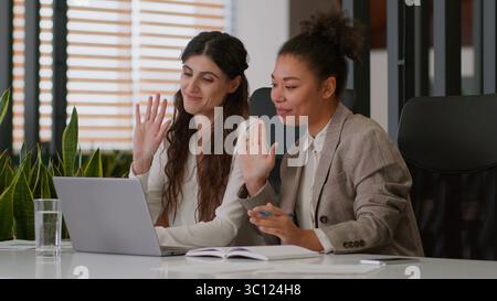 Multiracial girls African American Caucasian business women female friendly smiling colleagues multiethnic businesswomen partners online meet laptop Stock Photo