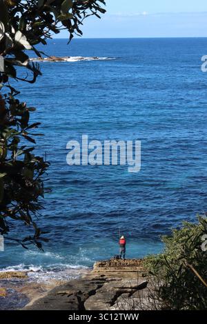 man rock fishing in a life jacket Stock Photo
