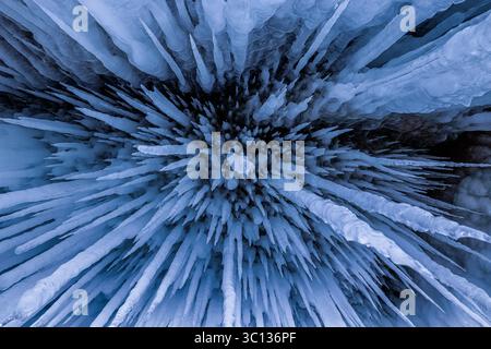 View of a mesmerizing spectacle of jagged, translucent icicles hanging like frozen daggers in a cave, Baikal, Irkutsk Oblast, Russia. Stock Photo