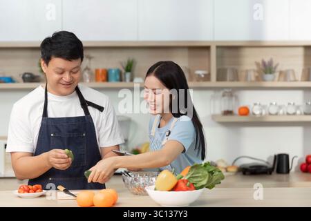 Cooking Together: Couple preparing fresh salad in a bright kitchen Stock Photo